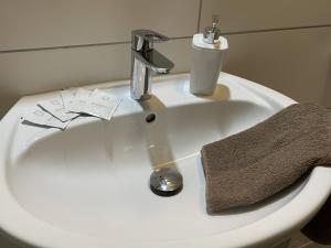 a bathroom sink with a towel and a faucet at Müller Apartments zur S-Bahn Oberschleißheim in Oberschleißheim