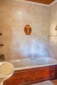 ein Badezimmer mit Badewanne und Waschbecken in der Unterkunft Owl House Marloth Park in Marloth Park
