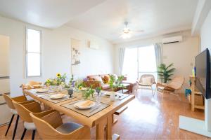 Una sala de estar con una gran mesa y sillas de madera. en Family Villa in Okinawa, en Wada