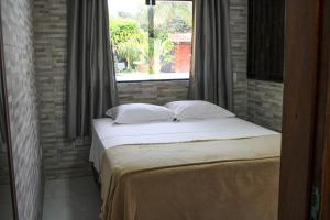 a bed in a room with a window at Harmonia Flats in Pipa