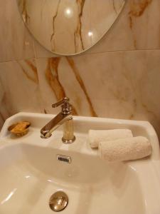 a bathroom sink with a faucet and towels on it at D OR et D ARGENT in Arceau