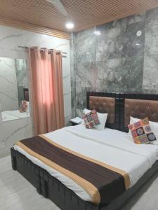 a bedroom with a large bed and a bathroom at Hotel Metro Residency Kalkaji in New Delhi