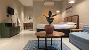 a bedroom with a bed and a table with a potted plant at The Twelve Palm Resort in Morjim