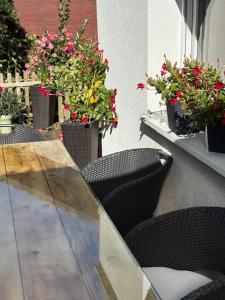 a table with chairs and flowers on a patio at Haus am Meer in Koserow in Ostseebad Koserow