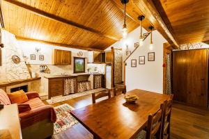 a living room with a wooden table and a kitchen at Casa vacanza Campotosto in Campotosto