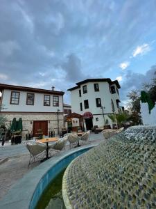 a pool in front of a building with chairs and a table at Boho Oldtown Apart and Hostel in Antalya