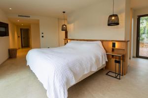 ein Schlafzimmer mit einem großen weißen Bett und einem Tisch in der Unterkunft luxury villa les Kiks 5 chambres, piscine chauffée, Lecci in Lecci