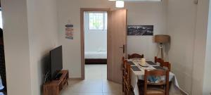 a dining room with a table and a room with a bed at Natageo in Loutraki