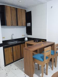 cocina con mesa de madera y armarios de madera en CASA VACANZA Cenaida Mono Titi, en Leticia