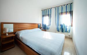 a bedroom with a large bed with blue curtains at Dimora Laguna -apeliving- Pellestrina Ve in Pellestrina