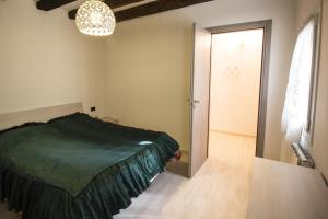 a bedroom with a bed and a door and a chandelier at Dimora Marchiada -apeliving- Pellestrina Ve in Pellestrina +1 photo