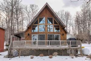 a log cabin in the snow with a large window at The Lodge on Lamoka in Bradford