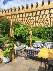 a wooden pergola with a bench and a table at Field View B&B in Eastrington