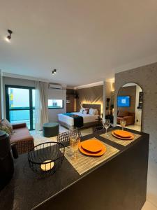una habitación de hotel con una cama y una mesa con dos vasos en Flat Praia Comfort Camburi, en Vitória