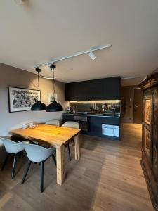 a kitchen and dining room with a wooden table and chairs at AVO 2 room wellness apartment in Laax