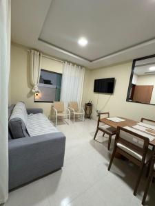 ein Wohnzimmer mit Sofa und Tisch in der Unterkunft Refúgio do Mel - Piscina e Forno a Lenha in Gravatá