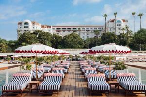 een rij stoelen met parasols voor een hotel bij Hôtel Barrière Le Majestic Cannes in Cannes