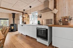 a kitchen with white cabinets and a stove top oven at 8566-Grenaa-Askevej-17 in Grenå Strand +16 photos