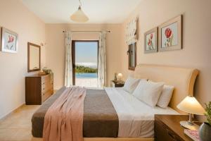a bedroom with a bed with a view of the ocean at Spartia Bay Cottage by Vintage Travel in Spartia +16 photos
