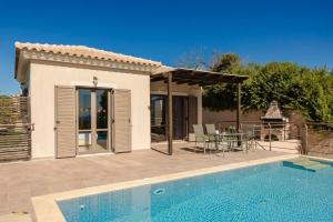 a villa with a swimming pool and a house at Spartia Bay Cottage by Vintage Travel in Spartia