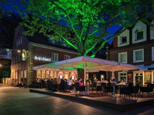 eine Gruppe von Menschen, die nachts an Tischen auf einer Straße sitzen in der Unterkunft Schlosshotel Ahaus in Ahaus