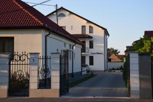 a white house with a gate in a street at Casa Manu in Sibiu