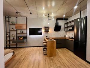 a kitchen with a black refrigerator and a counter at NEW Loft-style studio in Zhytomyr
