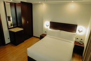 アディスアベバにあるTafach Hotelのベッドと鏡のあるホテルの部屋