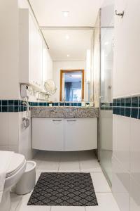 a bathroom with a toilet and a sink and a shower at Flat Parque do Ibirapuera - Jardins in São Paulo