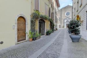 an empty street with potted plants and buildings at Living Salò in Salò