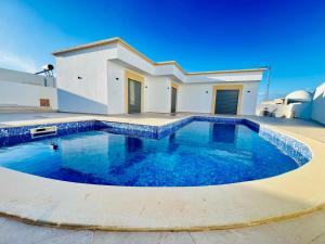 a large swimming pool in front of a house at Villa Arij in Midoun
