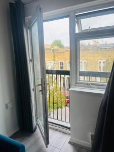 an open door to a balcony with a view of a building at The Bethnal Green Stay in London