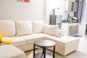 a living room with a white couch and a stool at Olmarei Experience Narok, in Narok