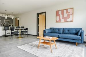 ein Wohnzimmer mit einem blauen Sofa und einem Tisch in der Unterkunft Blueground Northeast Bellevue rooftop nr Lake Sammamish SEA-904 in Highlands