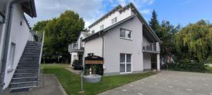 a white house with a stairway leading up to it at Ferienwohnung Strandparadies 7 in Juliusruh