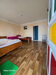 a large room with two beds and a wooden floor at Dara Homestay, Charkhole in Kalimpong +16 photos
