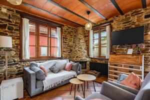 SomadoにあるLa Quintana de Somao, Casa Quintanaのソファとテレビのあるリビングルーム