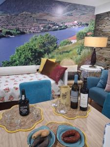 a living room with a table with bottles of wine at Casa do Vale Encantado in Cedovim