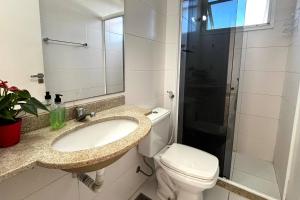 Un baño con lavabo, inodoro y ducha. en Vista do pôr de sol, 5 min a pé da praia Tartarugas, 3 supermercados e igreja universal, super arejado, en Rio das Ostras