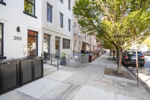 a sidewalk in front of a building with a tree at Blueground Greenpoint view nr McGolrick Park NYC-2071 in Brooklyn