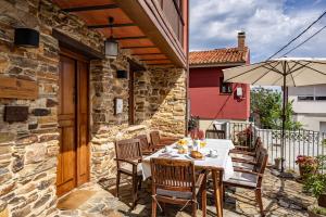 SomadoにあるLa Quintana de Somao, Casa Quintanaのテーブルと椅子と傘のあるパティオ