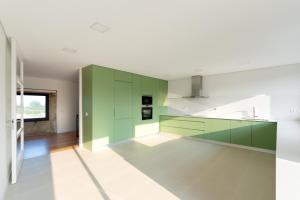 a kitchen with green cabinets and white appliances at Casa do Avô in Viana do Castelo