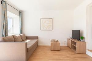 a living room with a couch and a tv at Quinta da Ponte in Odiáxere