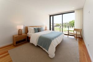 a bedroom with a large bed and a large window at Casa do Avô in Viana do Castelo +34 photos
