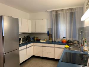 a kitchen with white cabinets and a stainless steel refrigerator at Fair House Near Düsseldorf- 5 Bedrooms, Garden, Terrace Parking in Niederdorla