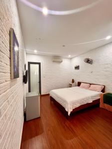a bedroom with a bed and a white wall at Homestay COAST HOUSE in Da Nang