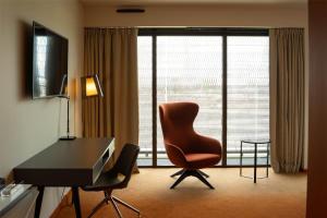 a hotel room with a desk and a chair at Radisson Blu Hotel Bordeaux in Bordeaux +95 photos