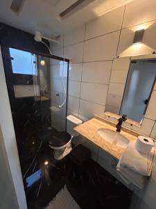 a bathroom with a sink and a mirror at Chalé Jorge in São Thomé das Letras