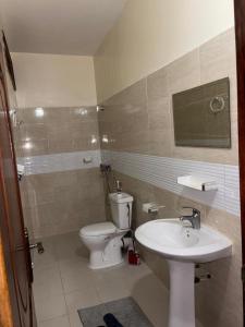 a bathroom with a toilet and a sink at Appartement meublé 3 chambres salon in Dakar