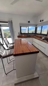 a kitchen with a table and chairs and windows at Sol & Río Refugio Serrano in Villa Las Rosas